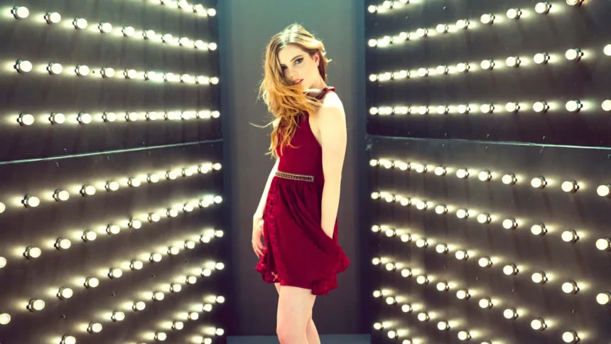 Sydney Sierota wearing a red dress posing inside a tunnel of glowing lights with cinematic reflections and elegant atmosphere wallpaper