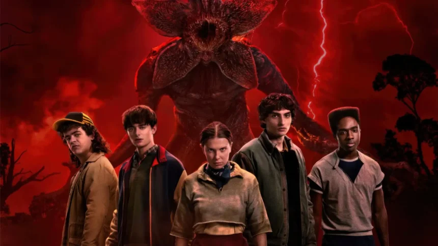 Group of teens standing in front of a giant shadow monster under a red stormy sky in a dark Stranger Things themed scene wallpaper