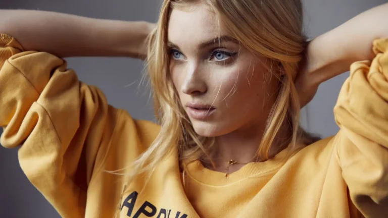 Close-up portrait of blonde model with blue eyes wearing yellow sweatshirt in soft natural lighting wallpaper