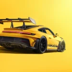 Yellow Porsche 911 GT3 RS supercar with large rear wing in a bright studio background wallpaper