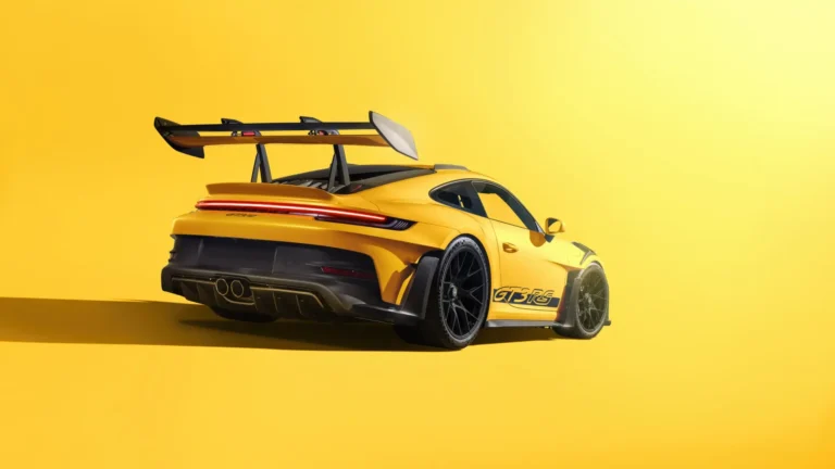 Yellow Porsche 911 GT3 RS supercar with large rear wing in a bright studio background wallpaper