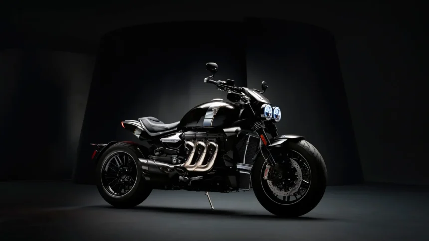 Black Triumph Rocket motorcycle in a dark studio with dramatic lighting wallpaper