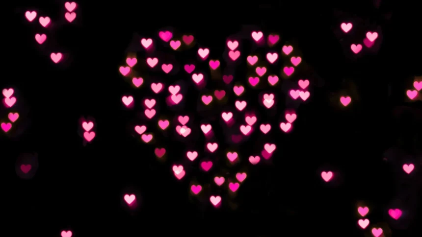 Pink glowing heart bokeh lights on dark romantic background wallpaper