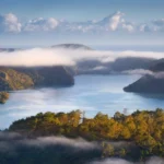 Misty coastal landscape of Whangaroa Northland New Zealand with calm ocean and green hills wallpaper