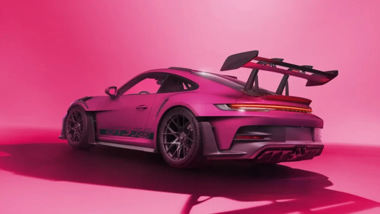 Pink Porsche 911 GT3 RS supercar with large rear wing in modern studio wallpaper