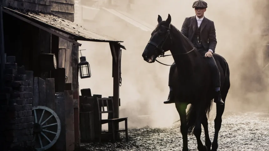Thomas Shelby riding a black stallion through a foggy Peaky Blinders street wallpaper