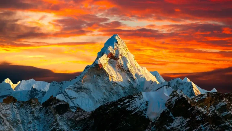 Golden sunset illuminating a snow-capped Himalayan mountain peak under a dramatic sky UHD wallpaper