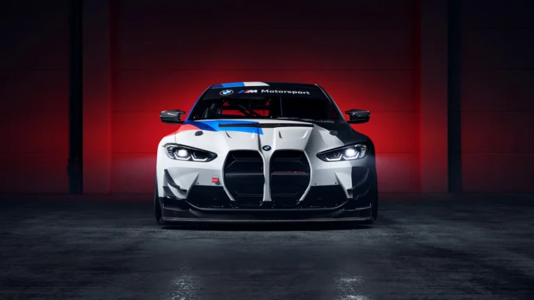 BMW M4 GT3 white race car with M Motorsport livery and glowing headlights against a dramatic red background UHD wallpaper