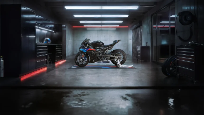 BMW S1000RR M Sport superbike with iconic M colors parked inside a cinematic dark garage with red and white lighting wallpaper.