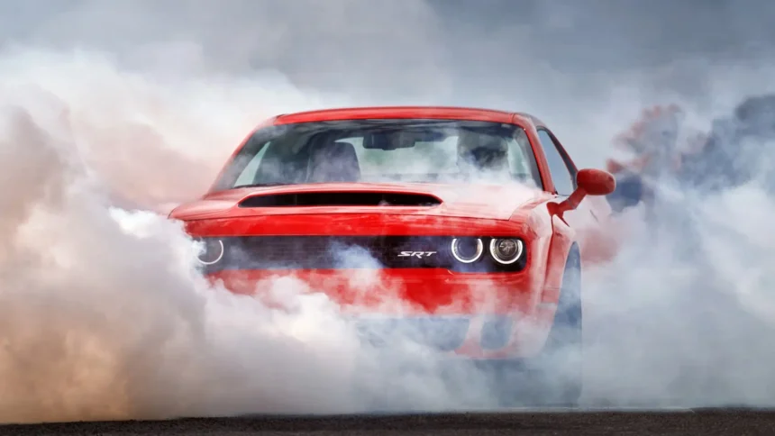 Red Dodge Challenger SRT performing burnout surrounded by thick tire smoke UHD wallpaper