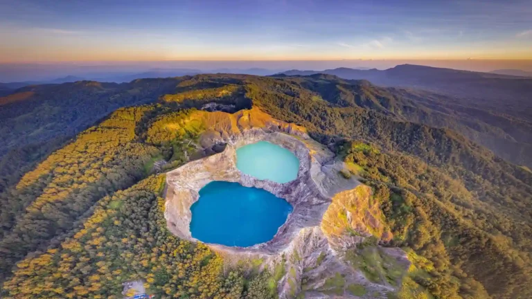 Kelimutu Crater Lakes in Indonesia with blue and turquoise volcanic lakes surrounded by lush mountains at golden hour wallpaper.