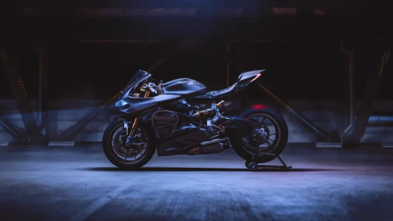 Ducati 1199 Panigale black superbike under dramatic blue lighting in a dark garage wallpaper.