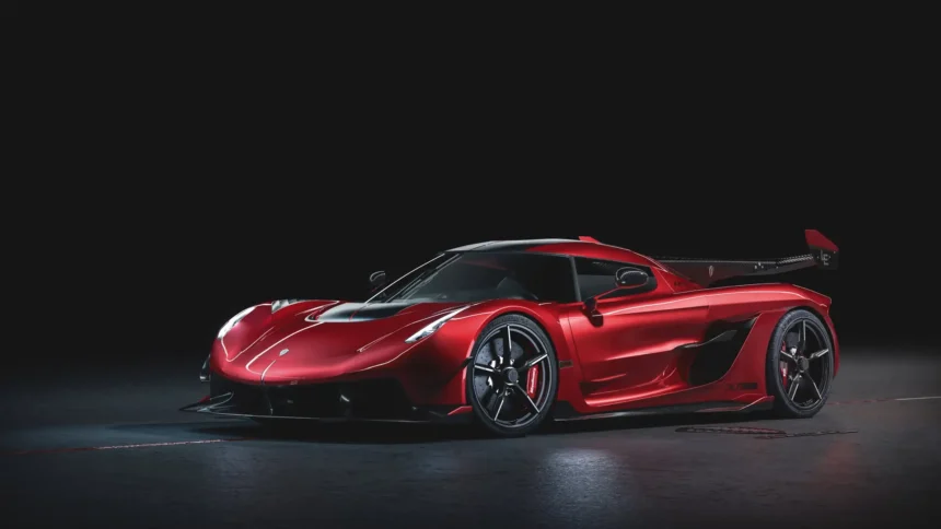 Koenigsegg Jesko red hypercar with carbon fiber aerodynamics and large rear wing in a dark studio wallpaper.