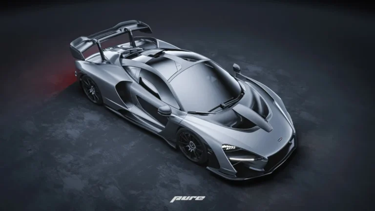 McLaren Senna silver hypercar with carbon fiber details and large rear wing in a dark studio wallpaper.