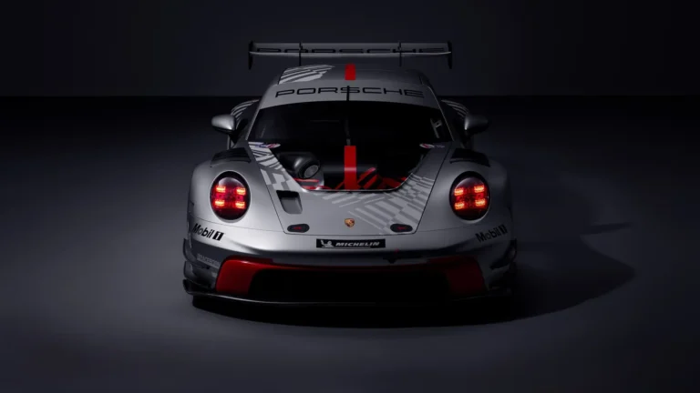 Porsche 911 GT3 R Rennsport race car with red accents and glowing lights in a dark studio wallpaper.