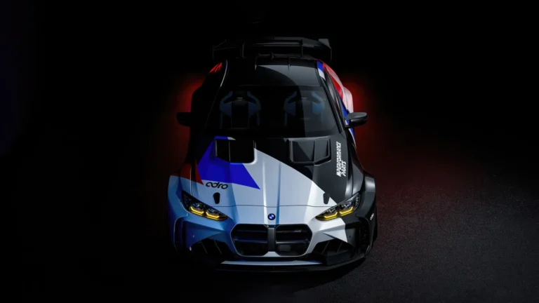 BMW M4 GT3 Dark Racing Edition with blue, white, and black motorsport livery, glowing yellow headlights, and a large rear wing against a dark background wallpaper.